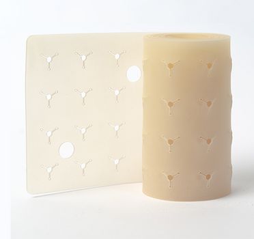 Die Abbildung zeigt eine beigefarbene, zylindrische Rolle aus einem Material, das an der Oberfläche mit einem wiederholten, dreifach angeordneten Vertiefungsmuster bearbeitet wurde.